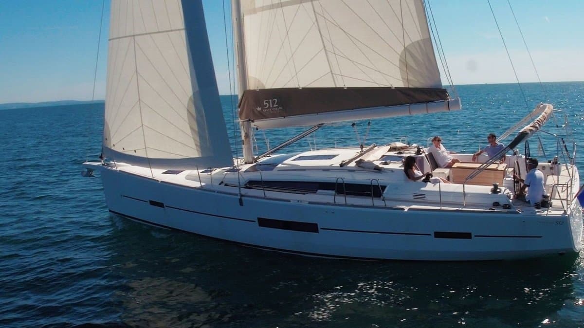 Eine Dufour 512 Grand Large unter Segeln vor Mallorca, im Besitz einer Gruppe von vier Eignern auf Kai